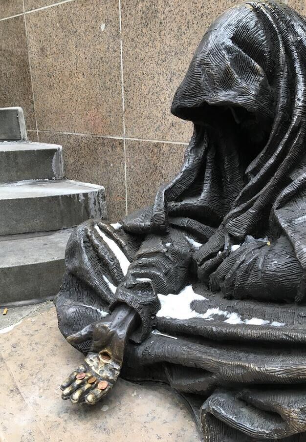 outdoor statue Jesus as a homeless beggar draws